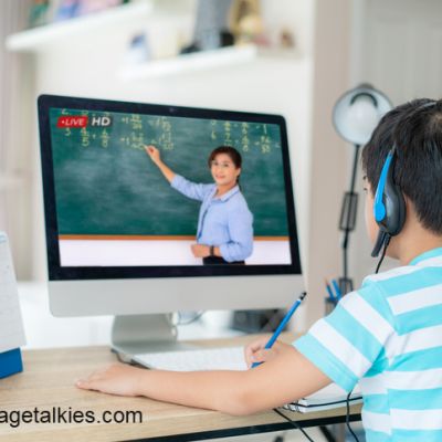 Asian  student boy video conference e-learning with teacher on computer in living room at home. E-learning ,online ,education and internet social distancing protect from COVID-19 virus.